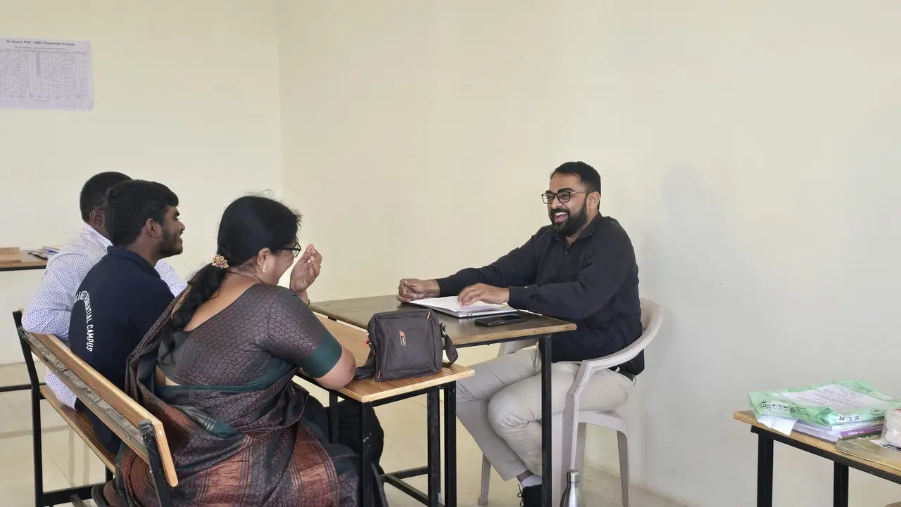 A parent in a one-to-one counselling conversation with a RIMA counsellor in a quiet classroom