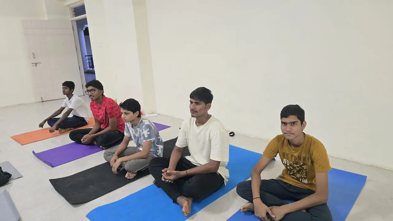 Students seated quietly on mats during a morning practice session